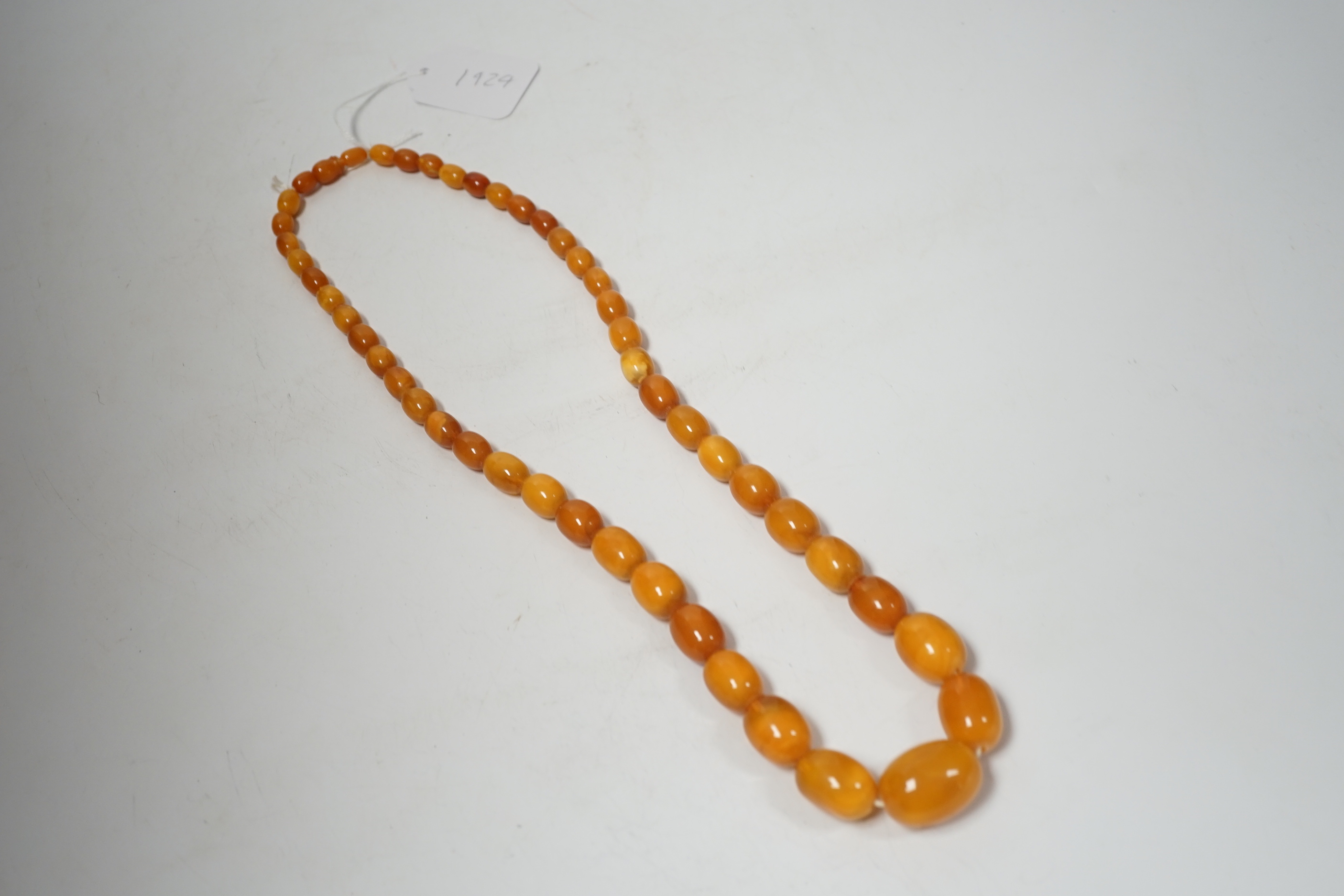 A single strand graduated oval amber bead necklace, 74cm, 83 grams.